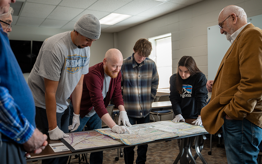 Students around a table studying a map