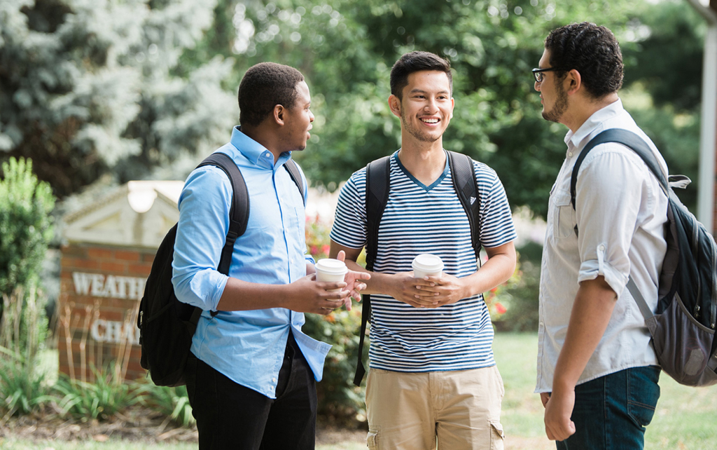 Group of students talking outside of a chapel