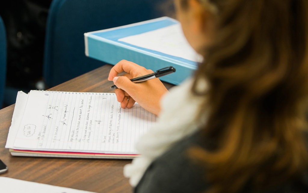 Student studying at a desk with a notebook