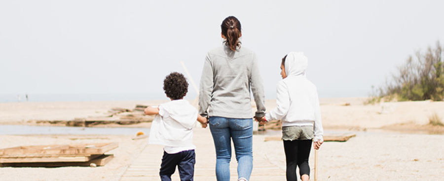 Family walking down a boardwalk on a beach