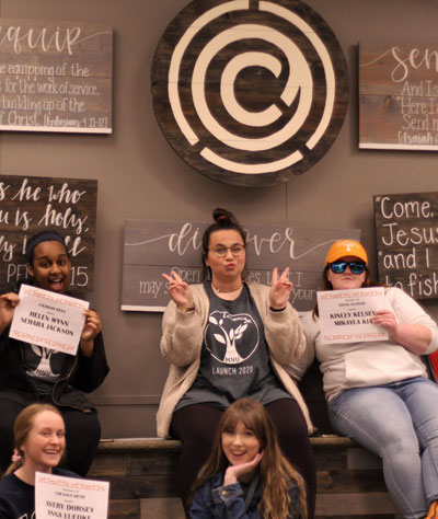 5 Girls posing, 3 holding name cards