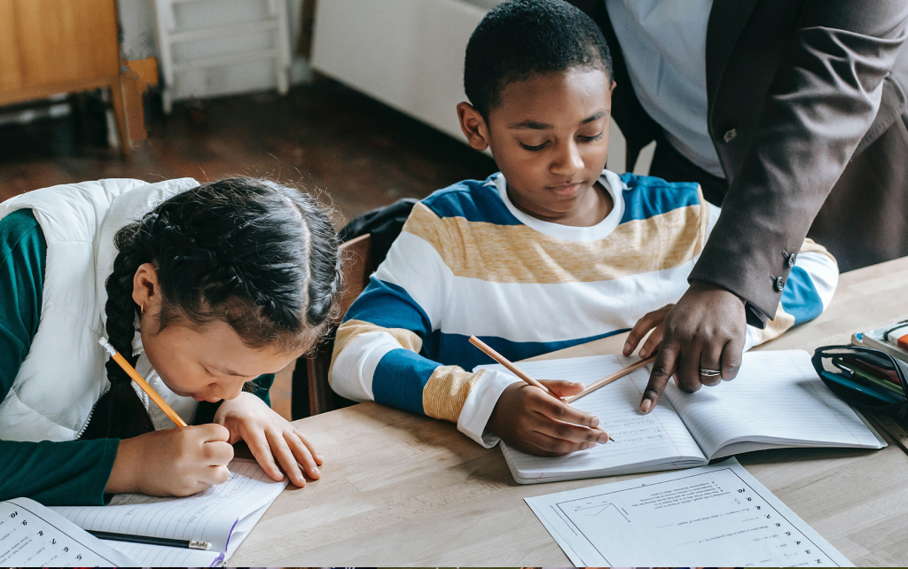 Children studying at a desk in a classroom