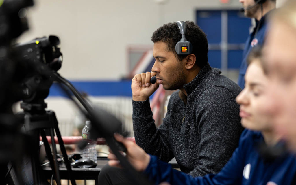 Student operating a sound board at a sports game