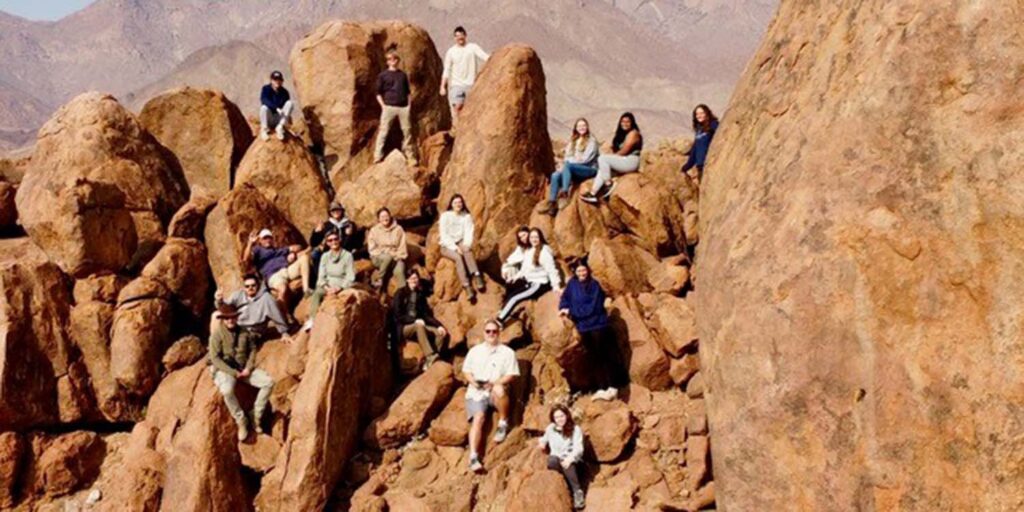 Students posed in a rock formation in Africa