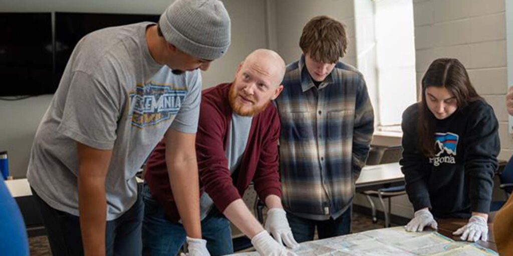 Darin Tuck and history students look at trail maps